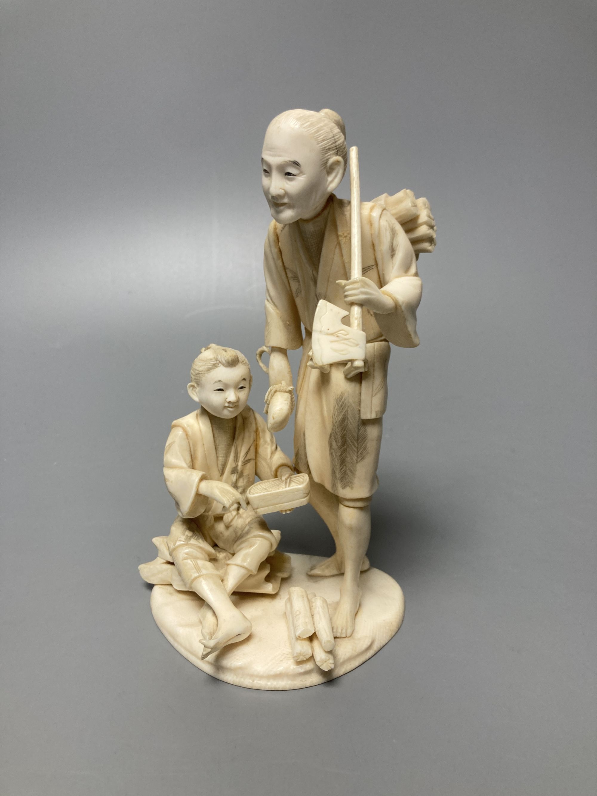 A Japanese sectional ivory okimono of woodsman, height 16cm